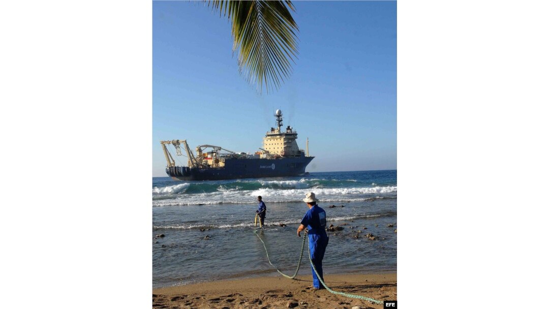 Obreros cubanos arrastran el cable submarino de fibra óptica en la playa de Siboney, en Santiago de Cuba.